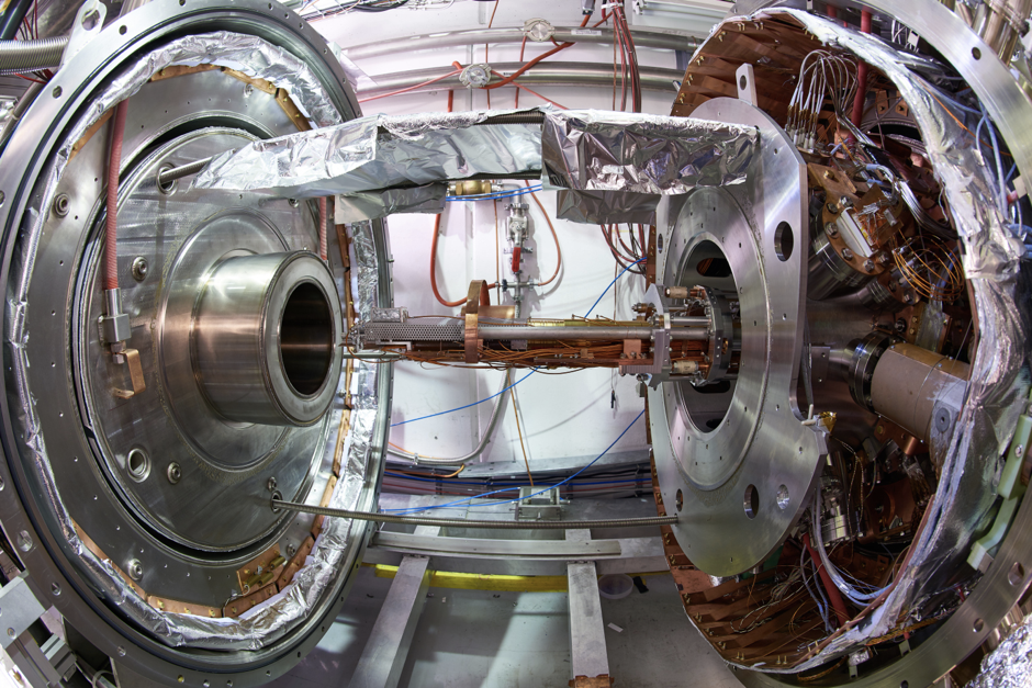 Antimatter factory at CERN, two circular metallic structures side to side connected with a thin hollow rod passing through the holes at their centers