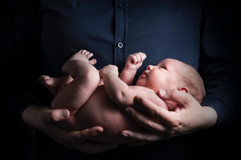 men in black shirt holding a baby
