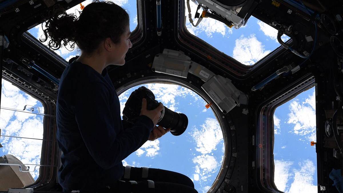an astronaut besides the window on international space station