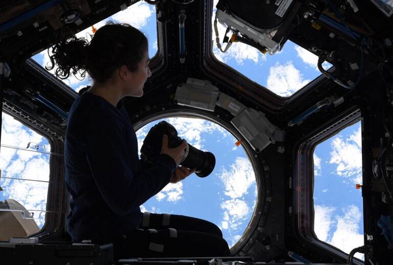 an astronaut besides the window on international space station